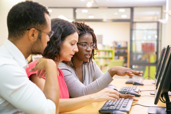 A group of people looking at a laptop